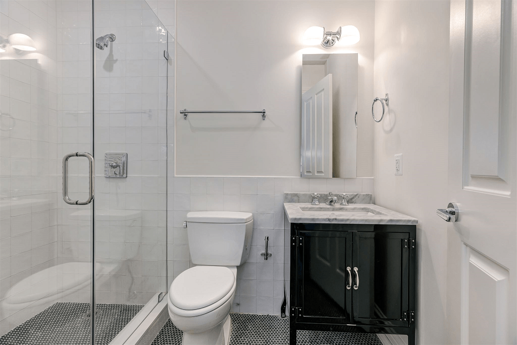 a white bathroom with a shower toilet and sink